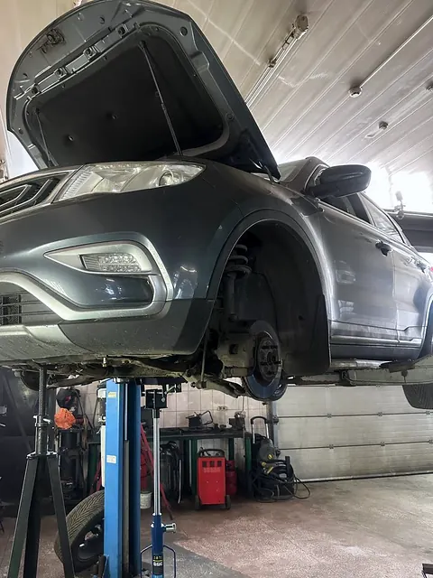 Автомобиль на подъёмнике с открытым капотом и снятым передним колесом, под силовой агрегат подведены стойки